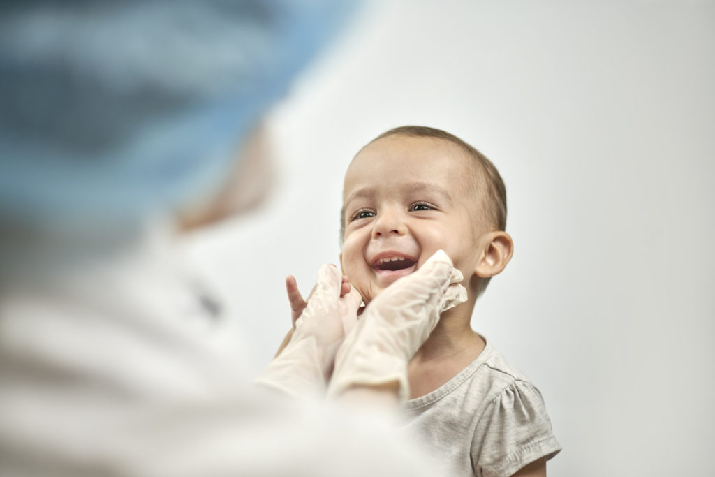 Child getting an exam before laser tongue-tie procedure