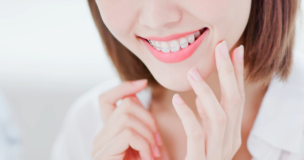 Woman smiling with retainer because she is pain free.